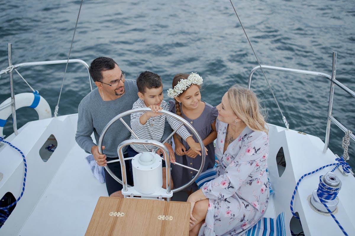 Family with two children at the helm of a sailing yacht