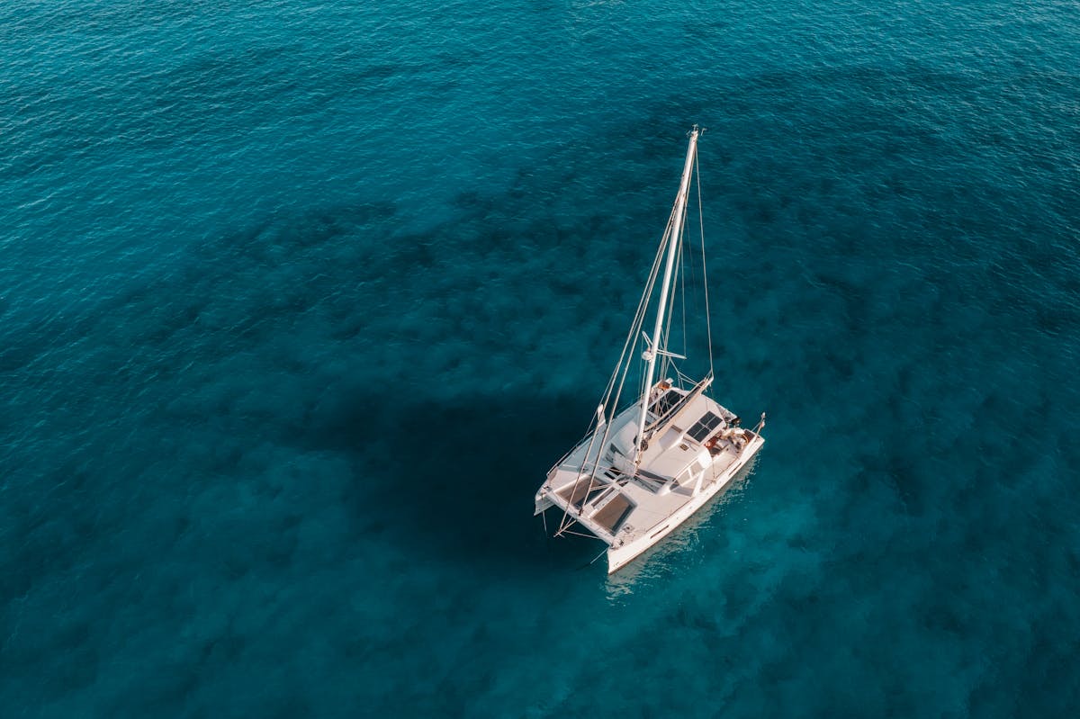 Aerial view of a catamaran on crystal clear water