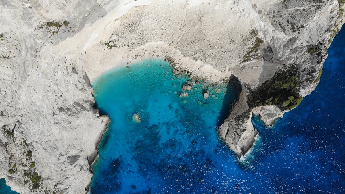 Navagio Beach in Zakynthos with turquoise water and boats in the bay