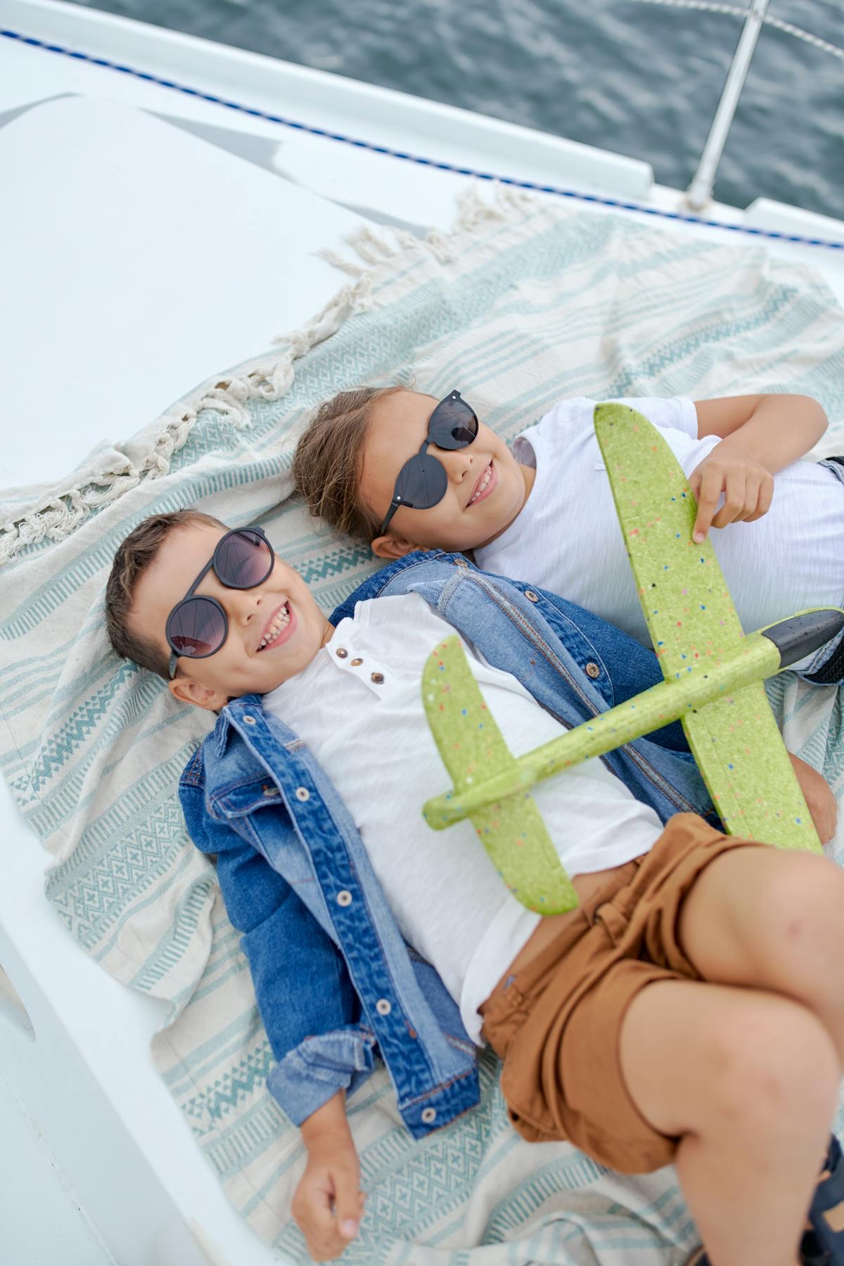 Two children relaxing on a yacht deck in the sun