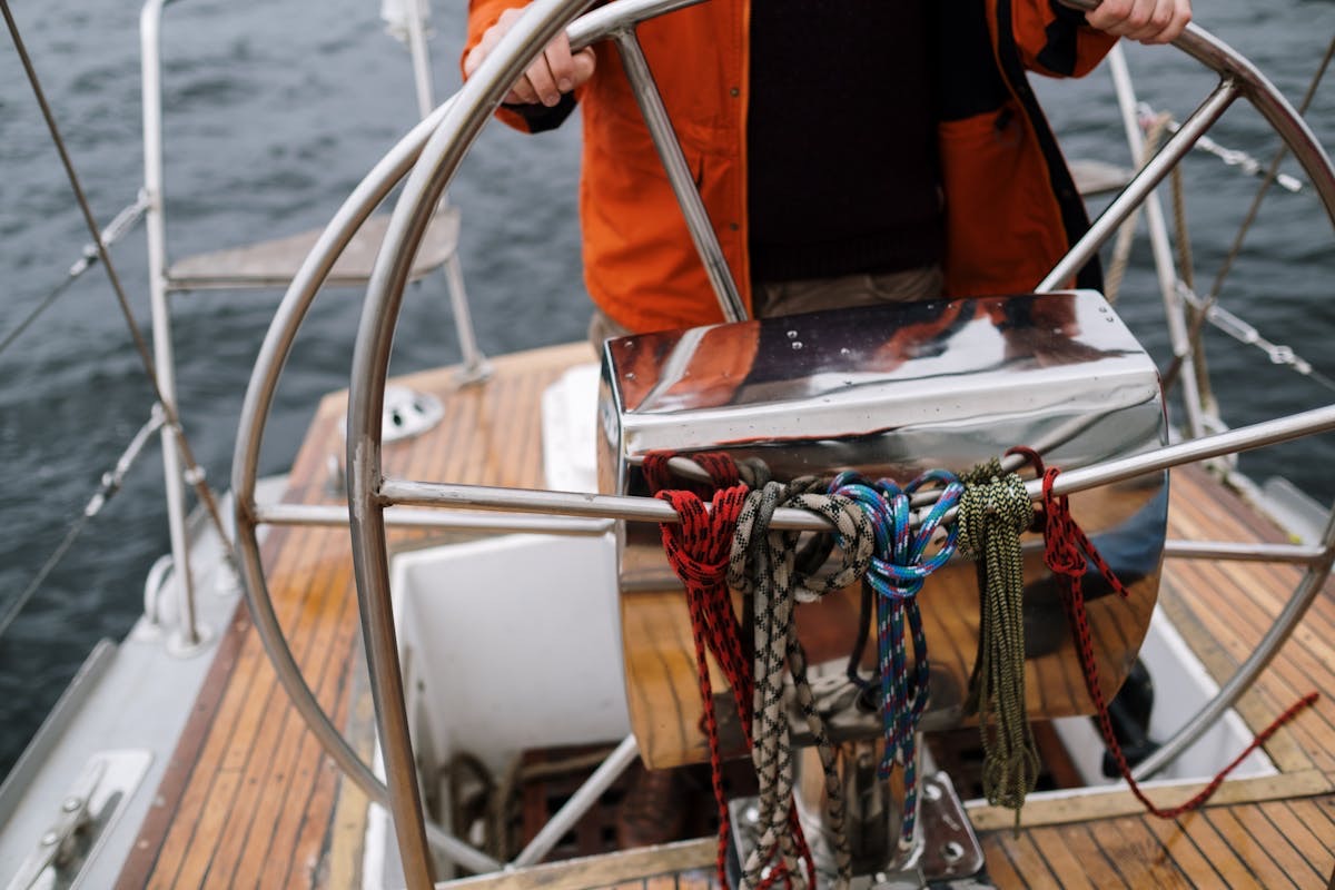 The helm of a sailing yacht under way, wheel and instruments in the foreground